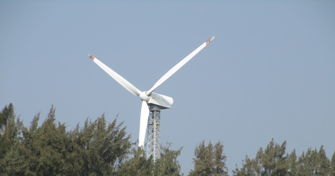 View of windmill in mid of trees .